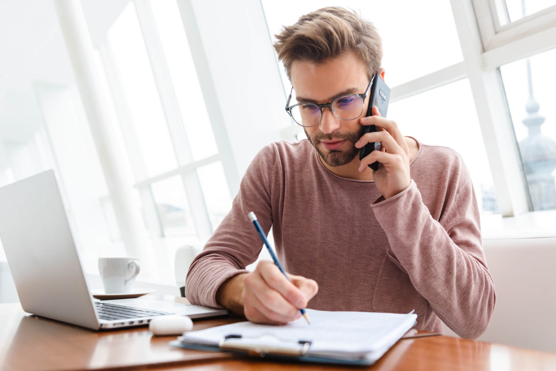 Commercial de la société Au'clean en communication téléphonique, préparant un devis avec un ordinateur portable